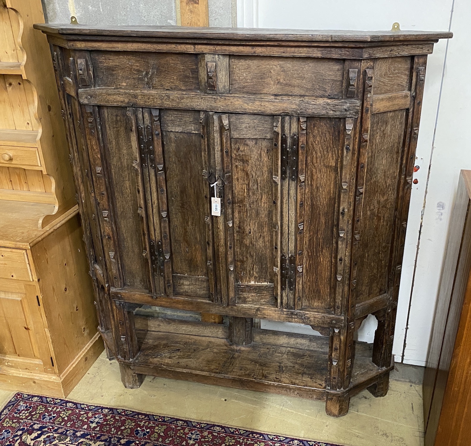 A 17th century style panelled oak side cabinet constructed from old timber, width 157cm, depth 29cm, height 164cm